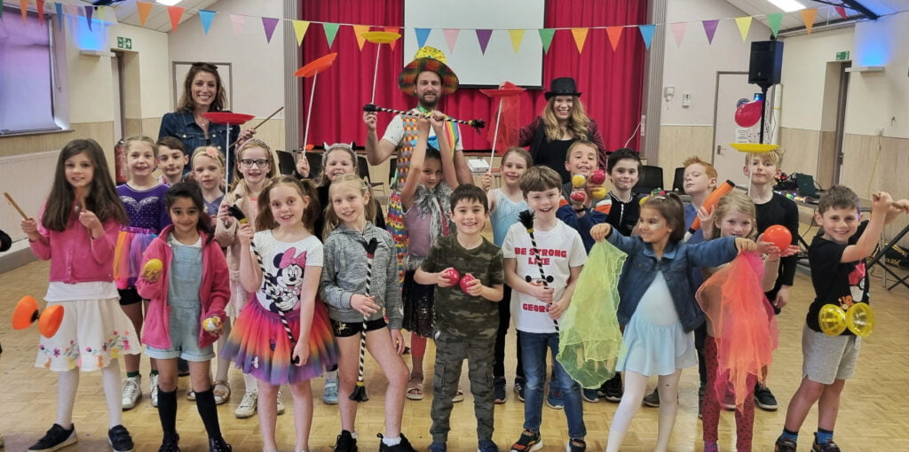 Smiling children with circus toys at a circus birthday party by Kinetic Circus